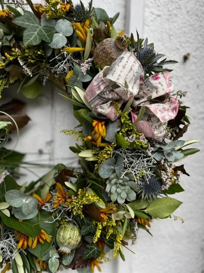 This is 14inch fresh flowers and foliages autumn wreath perfect for a door display.  Wreath to include oak leaf, limonium, thisle, kangaroo paws, solidago, dry poppies and mini succulents finished with vintage bow. Made by florist in Hayes, Bromley, Kent, UK