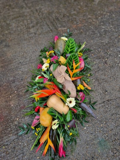 Caribbean funeral Coffin Spray with mixed tropical flowers and veggies done by florist in Bromley for free local delivery 