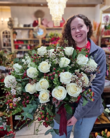 Luxury 24 white roses arranged in a vase with wax, eucalyptus, red berries. Made by Blooms and Candy Florist in Hayes, Bromley.