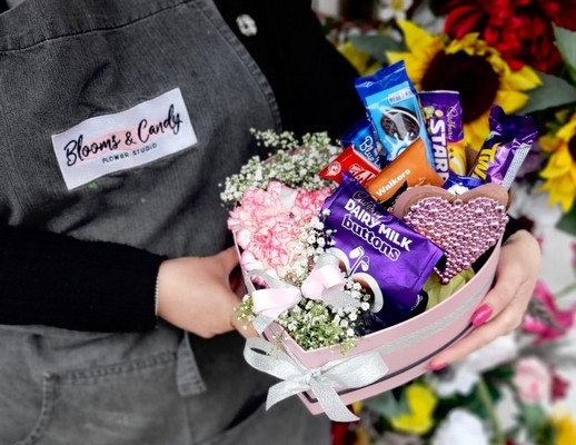 Pink heart shaped hat box with sweeties and plant inside, cute gift made by florist