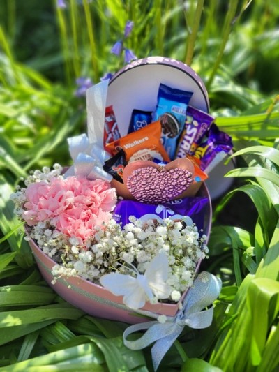 Pink heart shaped hat box with sweeties and plant inside, cute gift made by florist