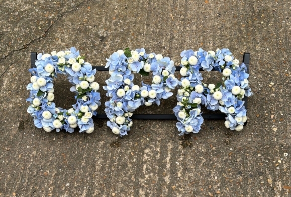 Funeral letters made of white button chrysanthemums and light blue hydrangeas. By best florist in Hayes, Kent, UK