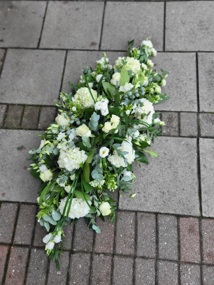 Mixed white flowers coffin toninclude white hydrangeas made by florist from Bromley.