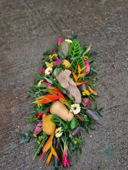 Caribbean funeral Coffin Spray with mixed tropical flowers and veggies done by florist in Bromley for free local delivery 