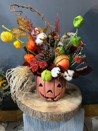 60cm tall arrangement in ceramic pumpkin pot made of dry and preserved leaves, Chinese lantern, silk larger acorn, fresh chrysanthemums, and matching decorations.  Beautiful gift to last till Halloween. Made by florist in Bromley, Kent