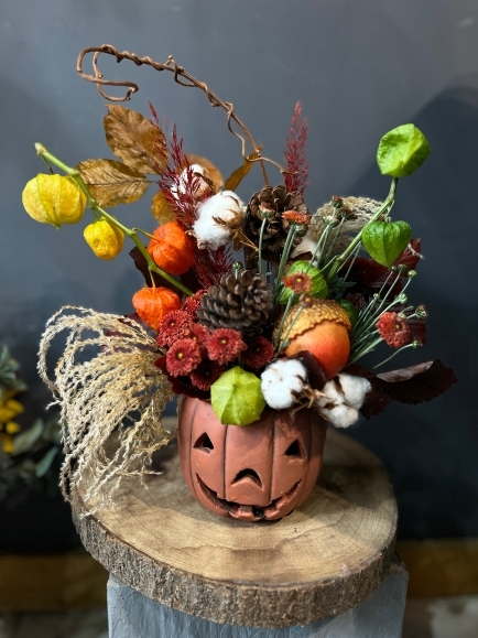 60cm tall arrangement in ceramic pumpkin pot made of dry and preserved leaves, Chinese lantern, silk larger acorn, fresh chrysanthemums, and matching decorations.  Beautiful gift to last till Halloween. Made by florist in Bromley, Kent