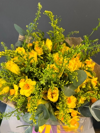 Spring finally is here with this bright striking bouquet made of Daffodils and Narcissus dressed with spring lime foliage and solidago. Made by florist in Bromley 